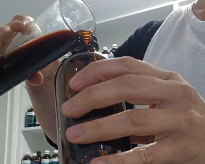 image of naturopathic herbalist Katie Harvison blending a liquid herbal tonic for clients. 
